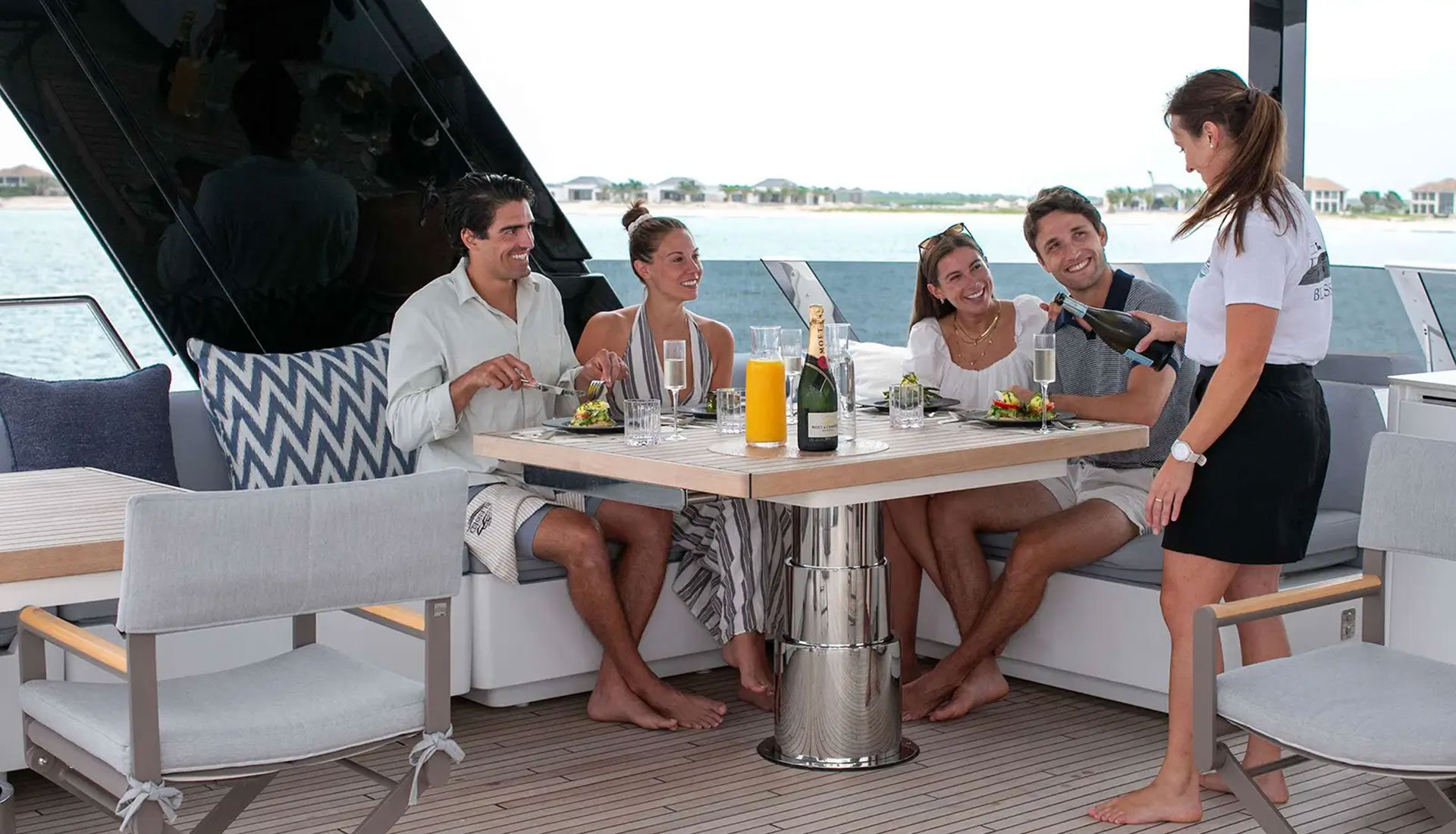 luxury-yacht-charter-guests-deck-dining-alfresco-mediterranean-2026