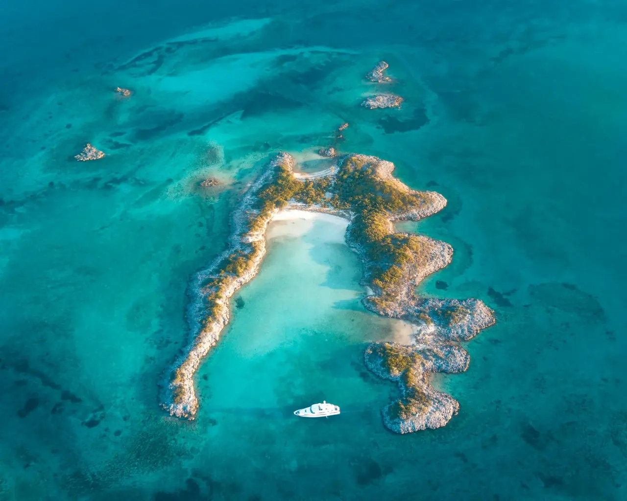 Aerial view of clear blue water and islands in the Bahamas.